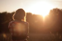 Woman looking out to morning sunshine